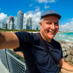 Middle age man taking a selfie next to the coast