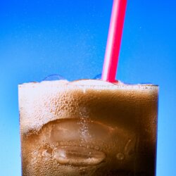 Cola drink in a glass with a straw