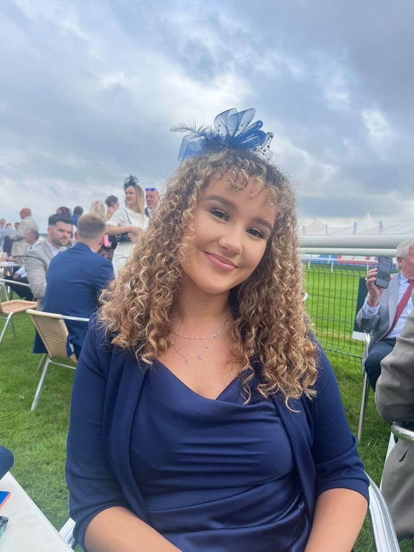 Woman in blue wearing a fascinator