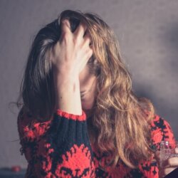 Woman with headache in front of Christmas tree