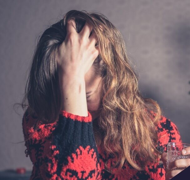 Woman with headache in front of Christmas tree