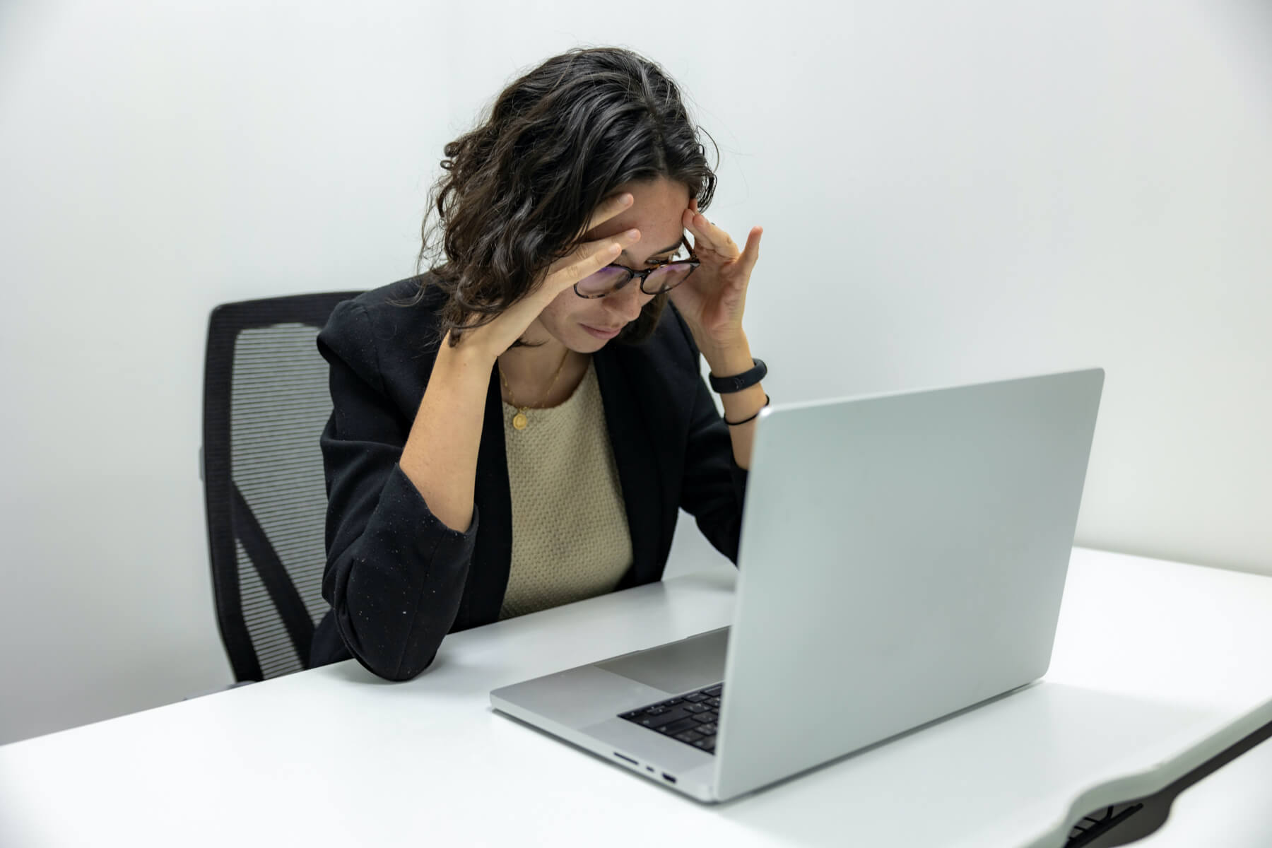 Woman with a headache working at a laptop computer